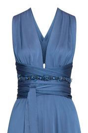 Detalle del escote en V y amarres con tira de brillos del vestido azul