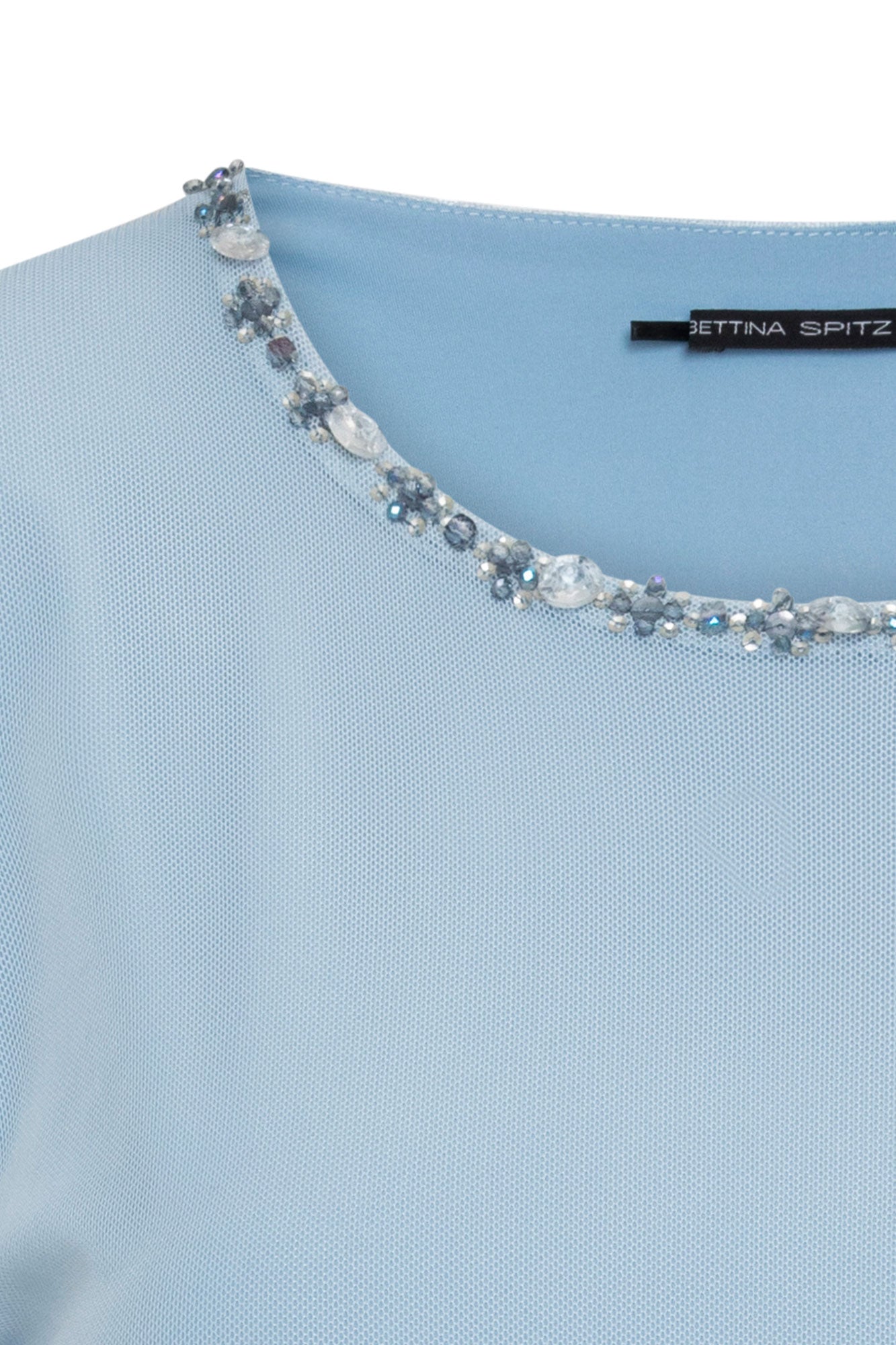 Detalle de los brillos en el cuello del top azul cielo